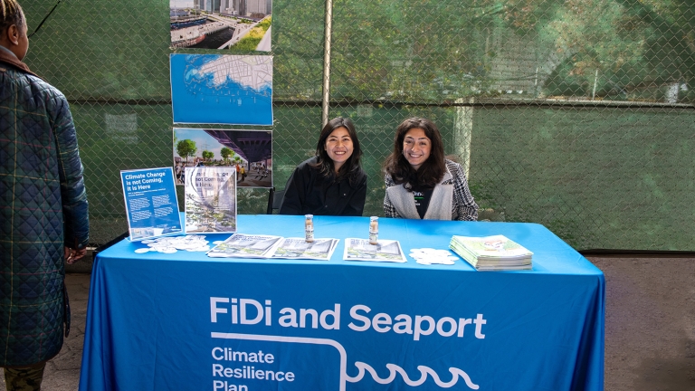 Two FiDi Seaport team members at a community engagement tabling event in Gotham Park.