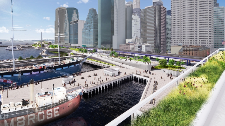 Aerial rendering of a vibrant Fulton Waterfront scene with people walking on wide piers, greenery along an elevated walkway, historic ships docked, and tall modern skyscrapers in the background under a blue sky.