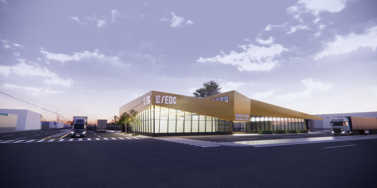 Rendering by Dattner Architects showing a modern, angular building with large glass windows and yellow accents sits beside a wide road. Trucks are parked nearby, and the sky is partly cloudy during sunset or sunrise. The building is labeled NYC/EDC.